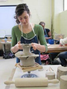 陶艺学生在转盘上塑造粘土.